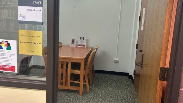 Photo showing doorway and window opening into small room with table and chairs and computer with desk